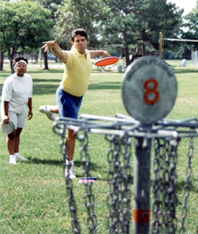 Two people playing disc golf. No dog area visible.