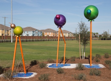 Colorful public-art sculpture and grassy field. No dog area visible.
