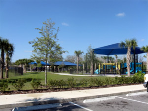 Shaded playground and park path. No dog area visible.